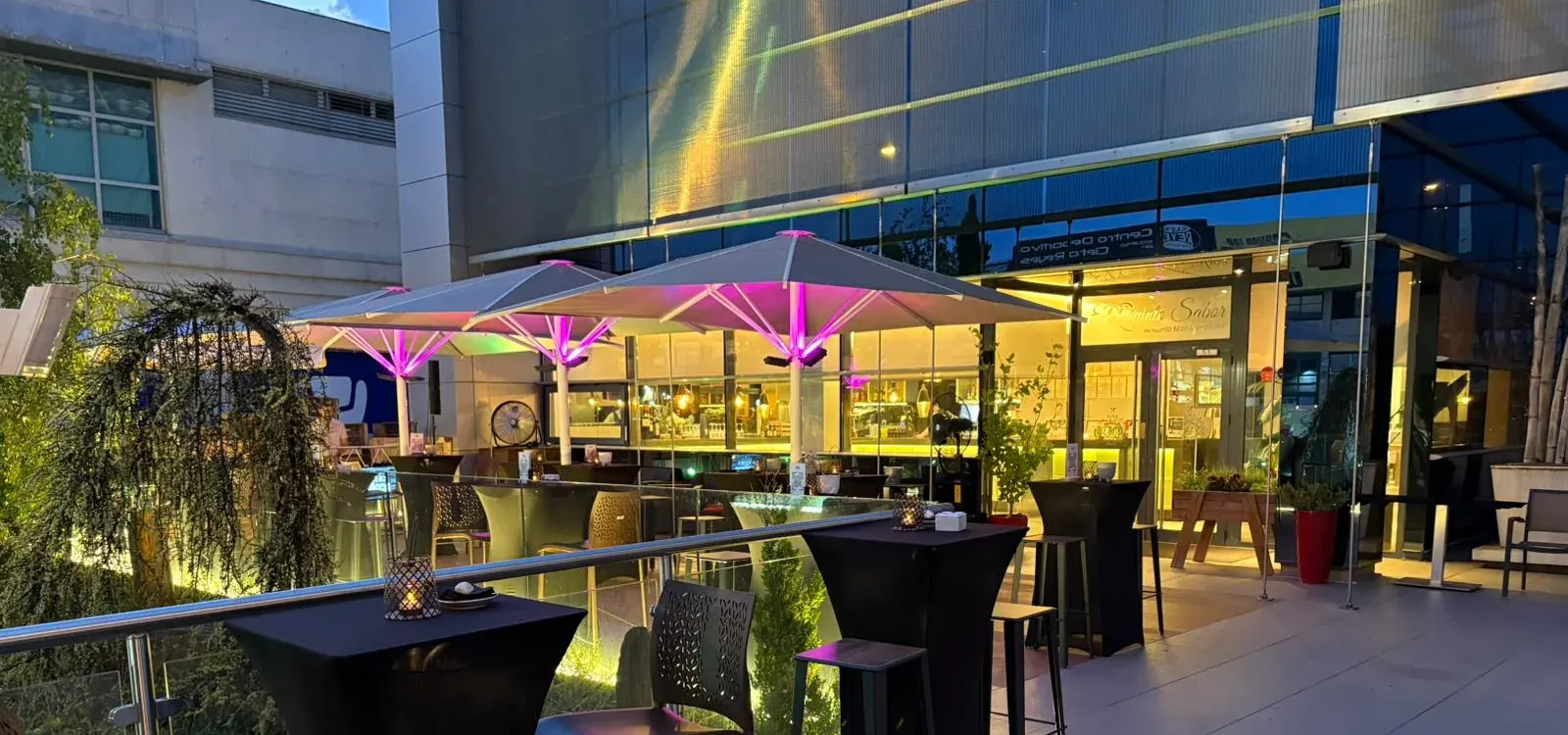 Terraza de El Quinto Sabor al anochecer, con la entrada iluminada