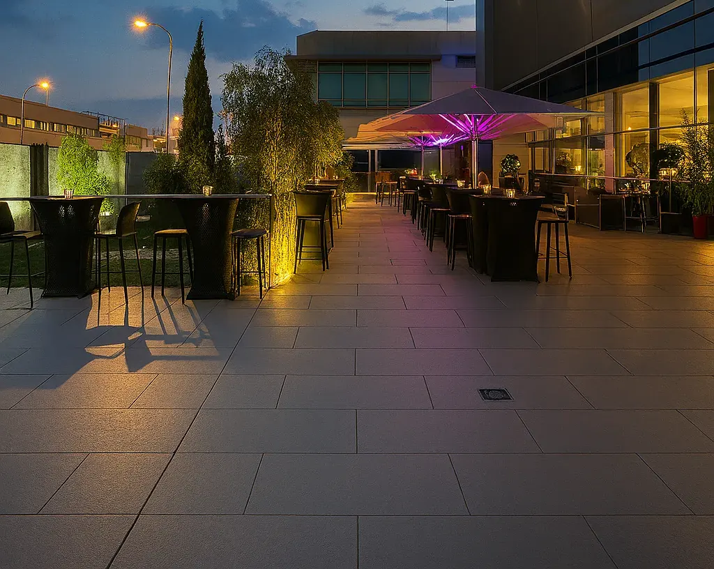 Terraza con sombrillas y mesas altas en una noche de verano